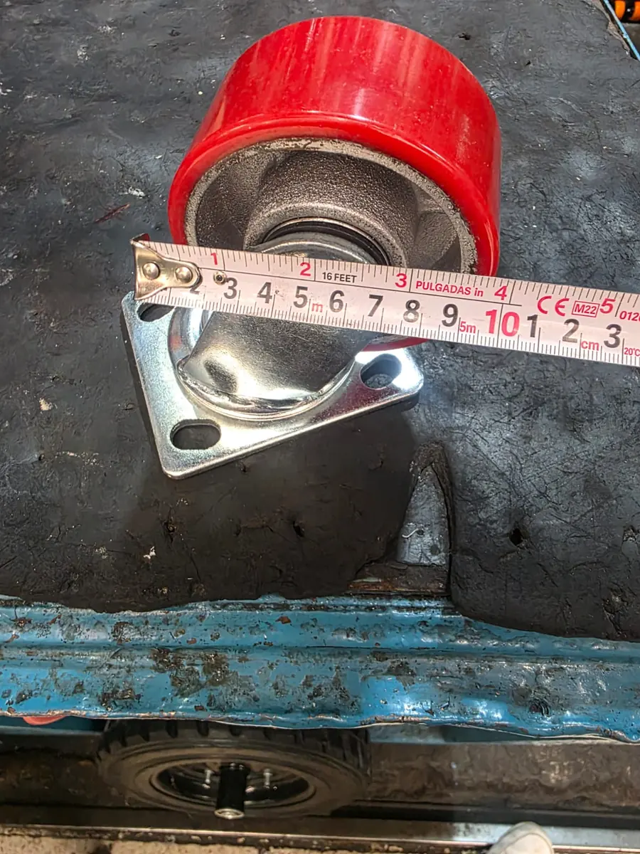 Rueda de poliuretano rojo junto a un flexómetro